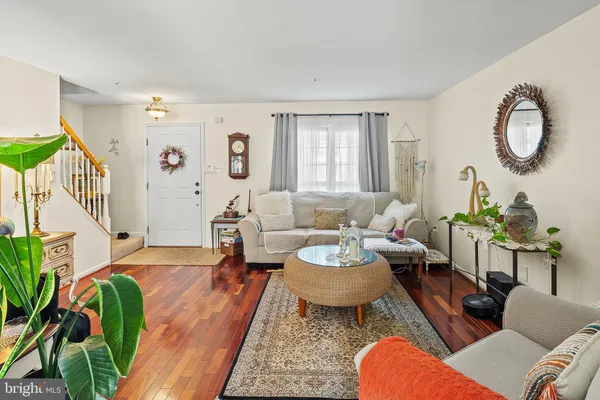a living room with furniture a rug potted plant and a window