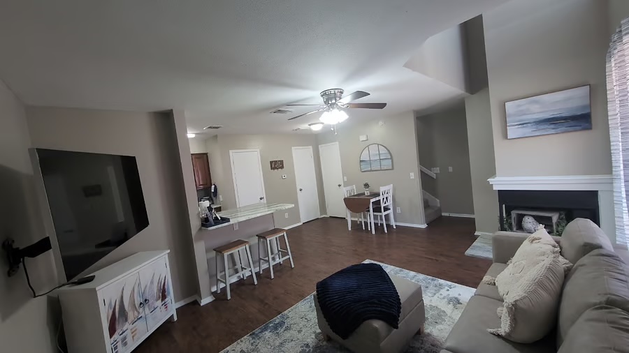 a living room with furniture a flat screen tv and a fireplace