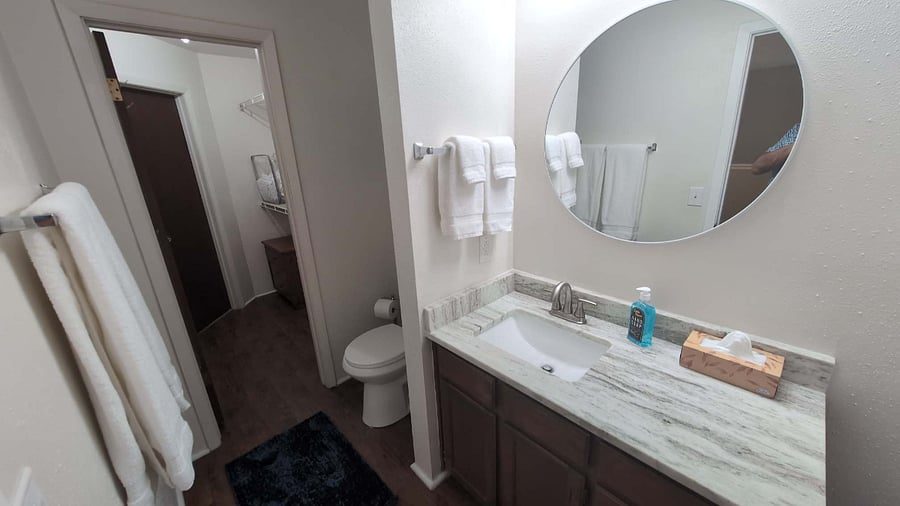 1305 West Villa Maria Road, Unit F104 Bryan, TX 77801 - Photo 8 of 9 a bathroom with a sink a toilet a mirror and vanity