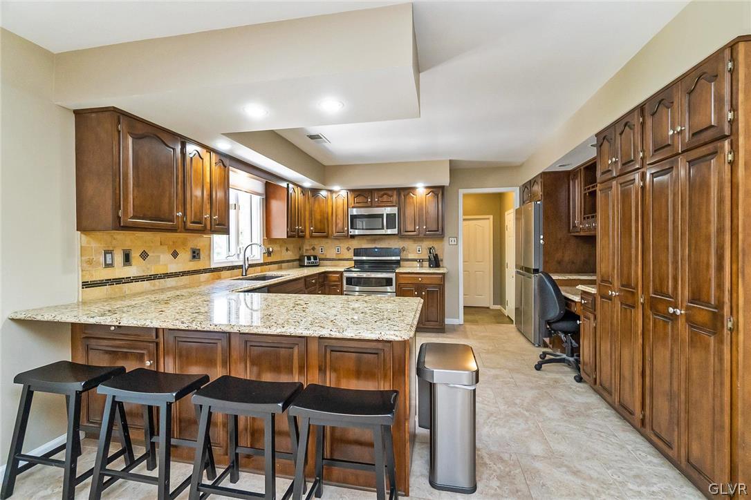 640 Macada Road Bethlehem, PA 18017 - Photo 13 of 48 a kitchen with stainless steel appliances granite countertop table chairs refrigerator and microwave