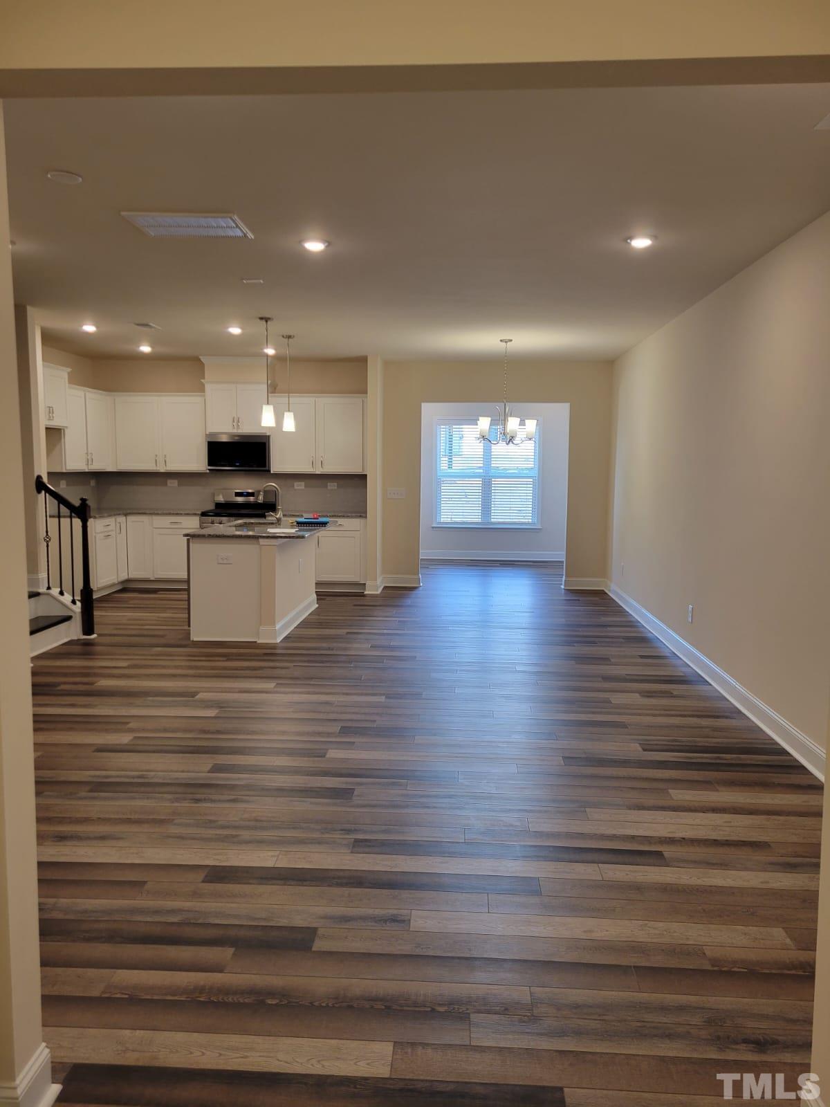 1178 Citadel Avenue Durham, NC 27713 - Photo 2 of 15 a view of a kitchen with kitchen island a sink wooden floor and a living room view