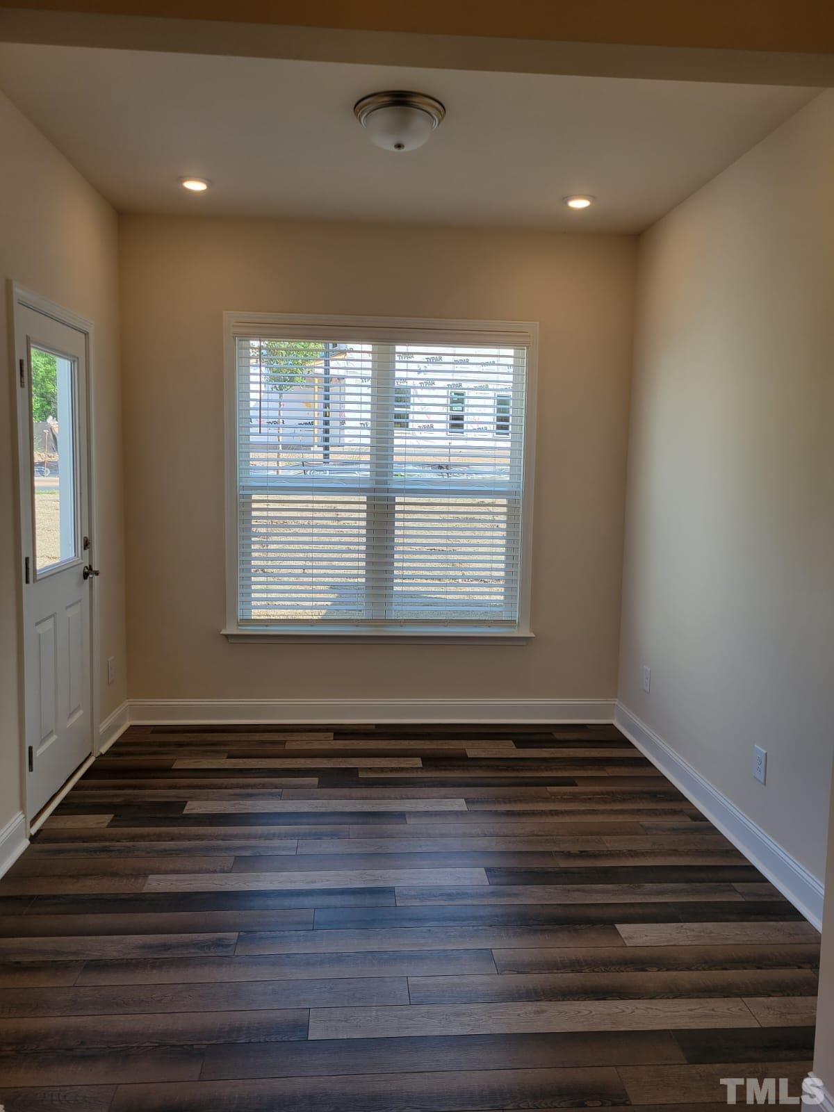 1178 Citadel Avenue Durham, NC 27713 - Photo 4 of 15 a view of an empty room with wooden floor and a window
