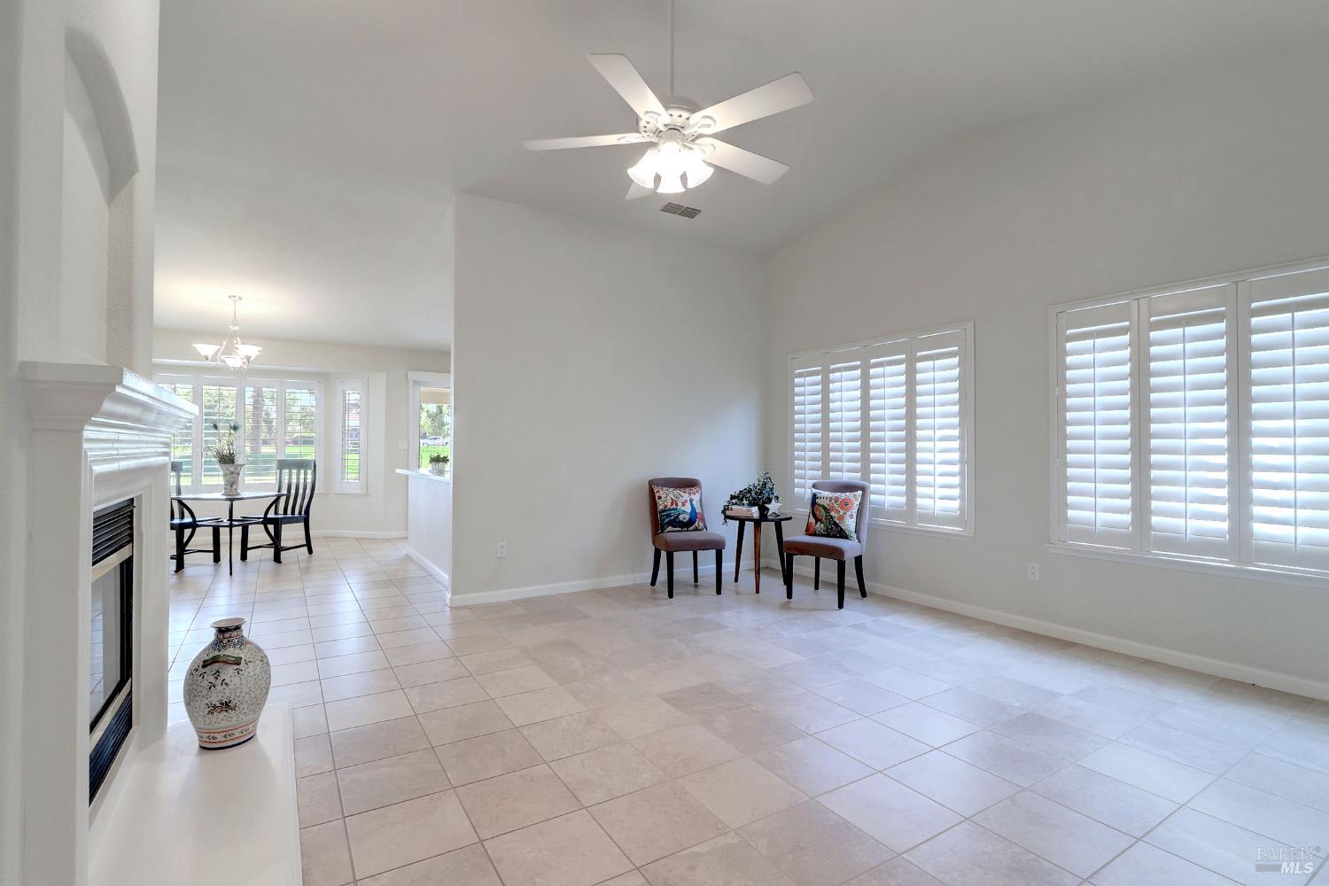 359 Glenn Lakes Drive Rio Vista, CA 94571 - Photo 2 of 34 living room with tile flooring, ceiling fan, plantation shutters, and fireplace