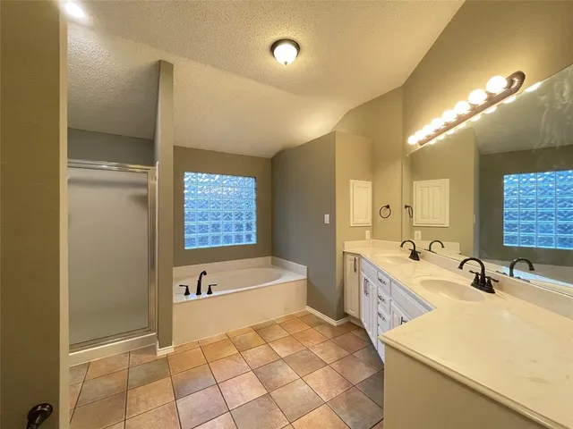 a spacious bathroom with a double vanity sink a mirror and a bathtub