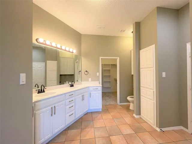 a bathroom with a granite countertop sink mirror and a toilet