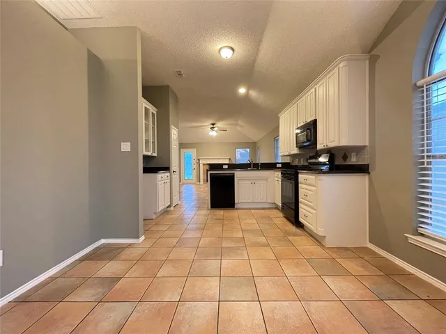 a large white kitchen with cabinets and a stove top oven