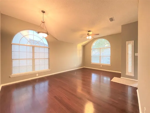 a view of a room with wooden floors and windows