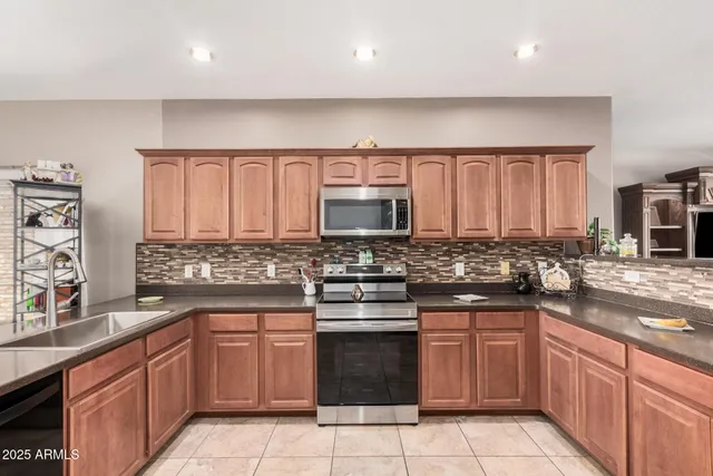 a kitchen with stainless steel appliances granite countertop a sink stove and microwave