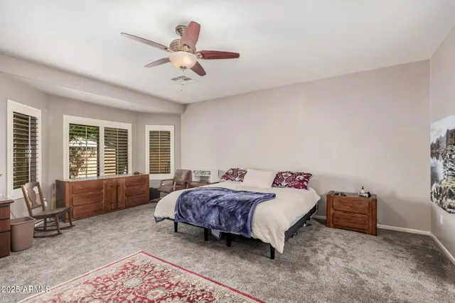 a bedroom with a bed flat screen tv and a large window