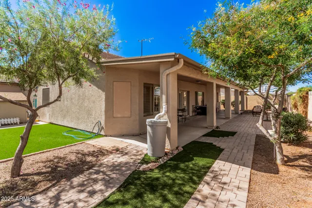 a view of a patio with table and chairs potted plants and large tree