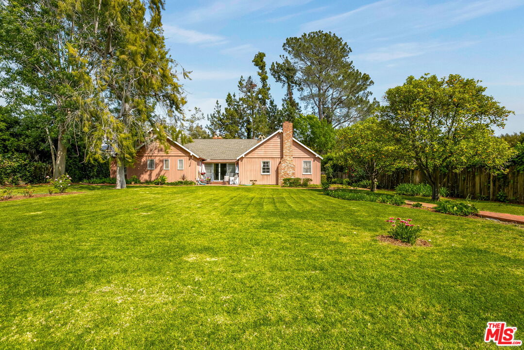 1639 Mandeville Canyon Road Los Angeles, CA 90049 - Photo 4 of 10 a view of a house with yard and tree s