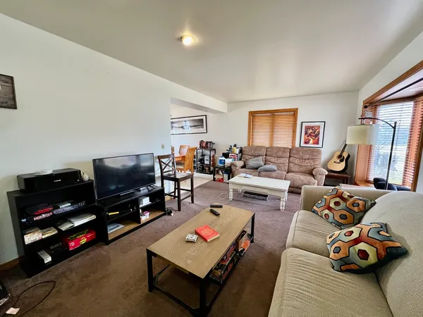 a living room with furniture a flat screen tv and a window