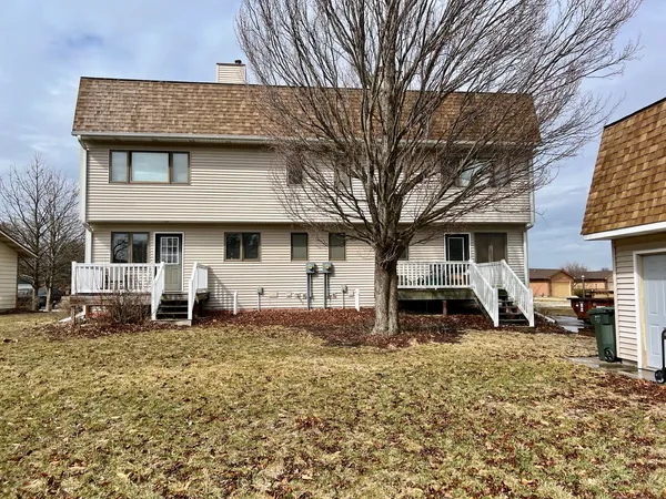 a front view of a house with cars parked