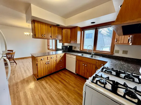 a kitchen with stainless steel appliances a sink a stove and wooden floor