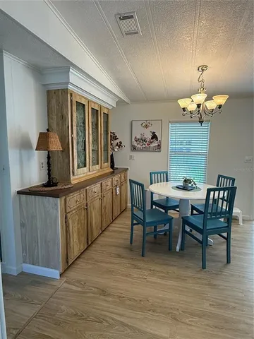 a view of a dining room with furniture and chandelier