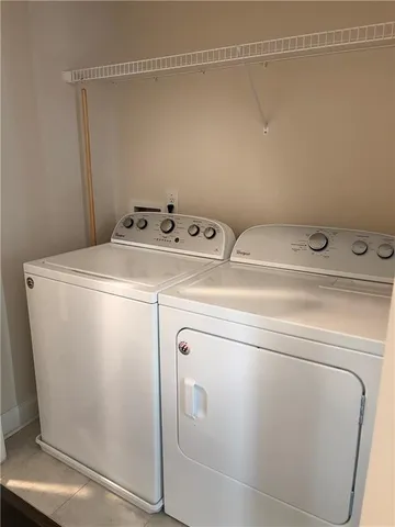 an empty room with a window and chandelier