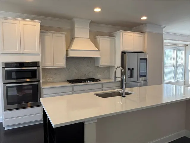 a kitchen with kitchen island a sink appliances and cabinets