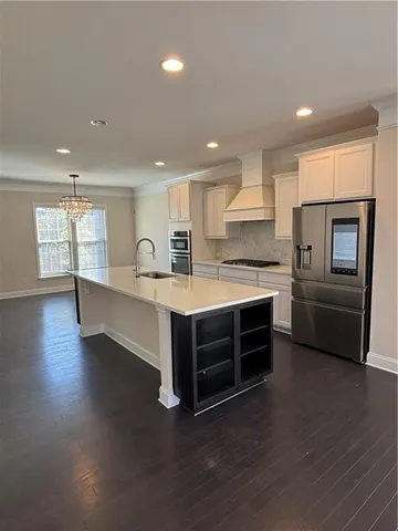 a kitchen with kitchen island white cabinets and stainless steel appliances