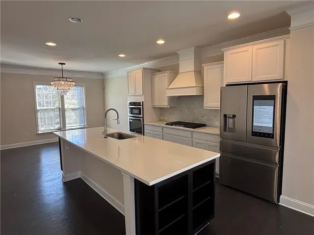 a kitchen with stainless steel appliances granite countertop a sink a stove and a refrigerator