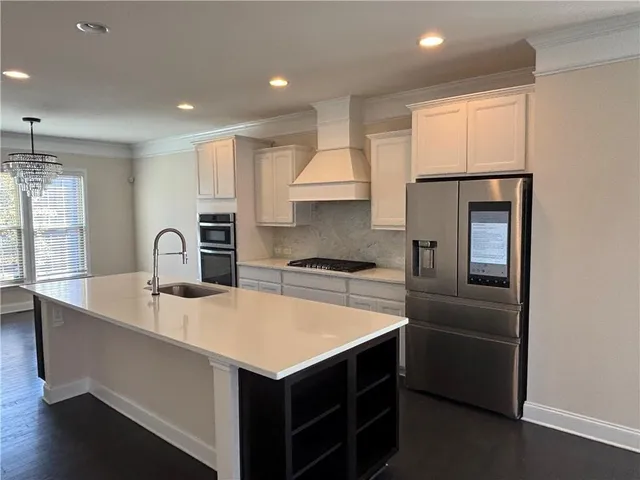 a kitchen with kitchen island a sink appliances and cabinets