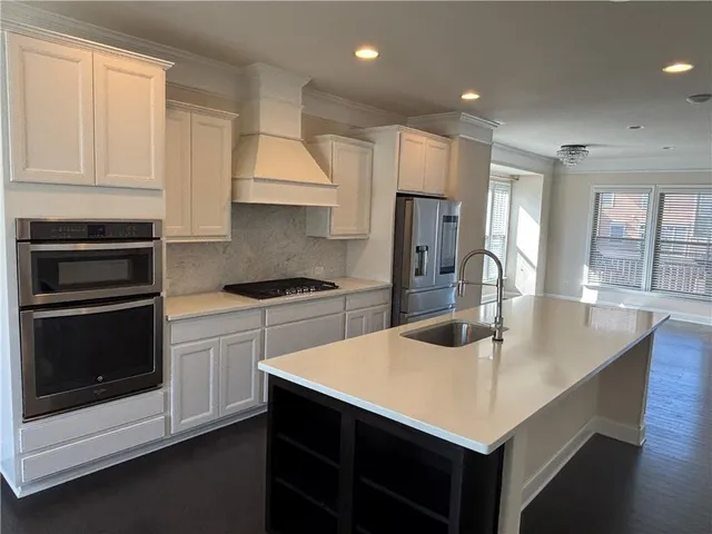 a large kitchen with wooden floors and stainless steel appliances