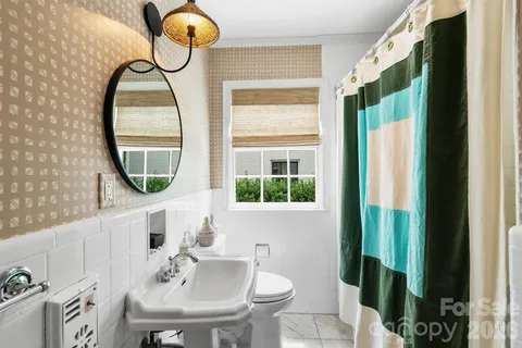 a bathroom with a sink mirror and a window