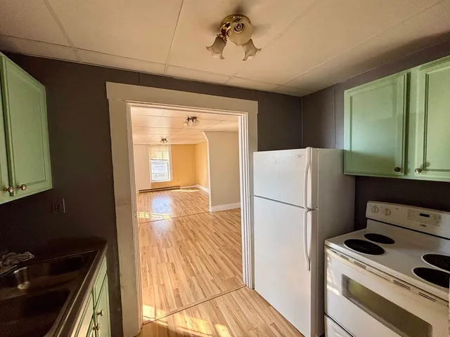 a white refrigerator freezer and a stove sitting inside of a kitchen