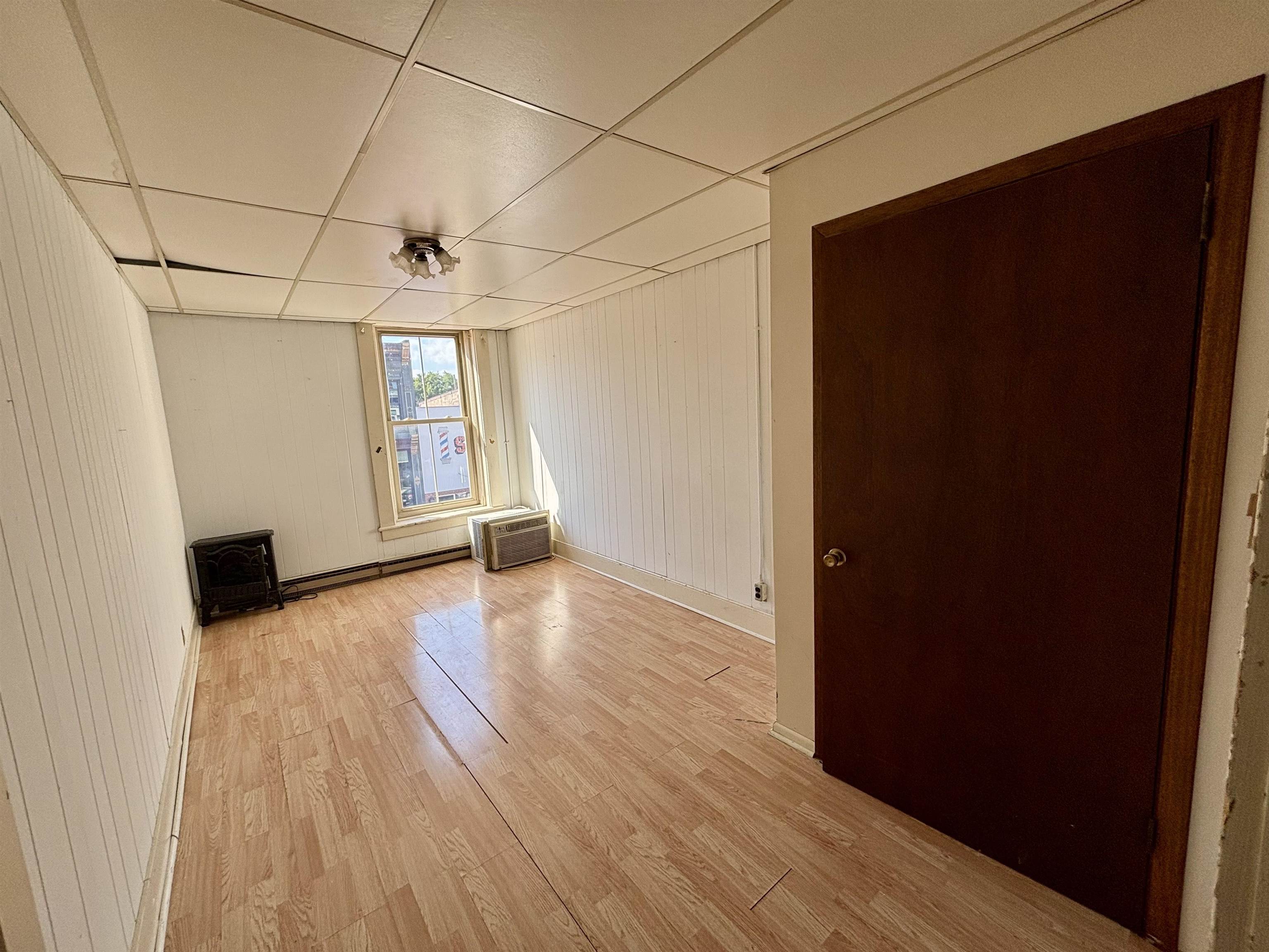 101 West Market Street Mount Carroll, IL 61053 - Photo 14 of 26 an empty room with wooden floor and windows