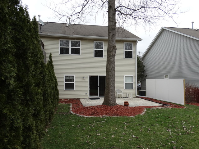 544 Birch Road Woodstock, IL 60098 - Photo 24 of 25 a view of a white house next to a yard with big trees