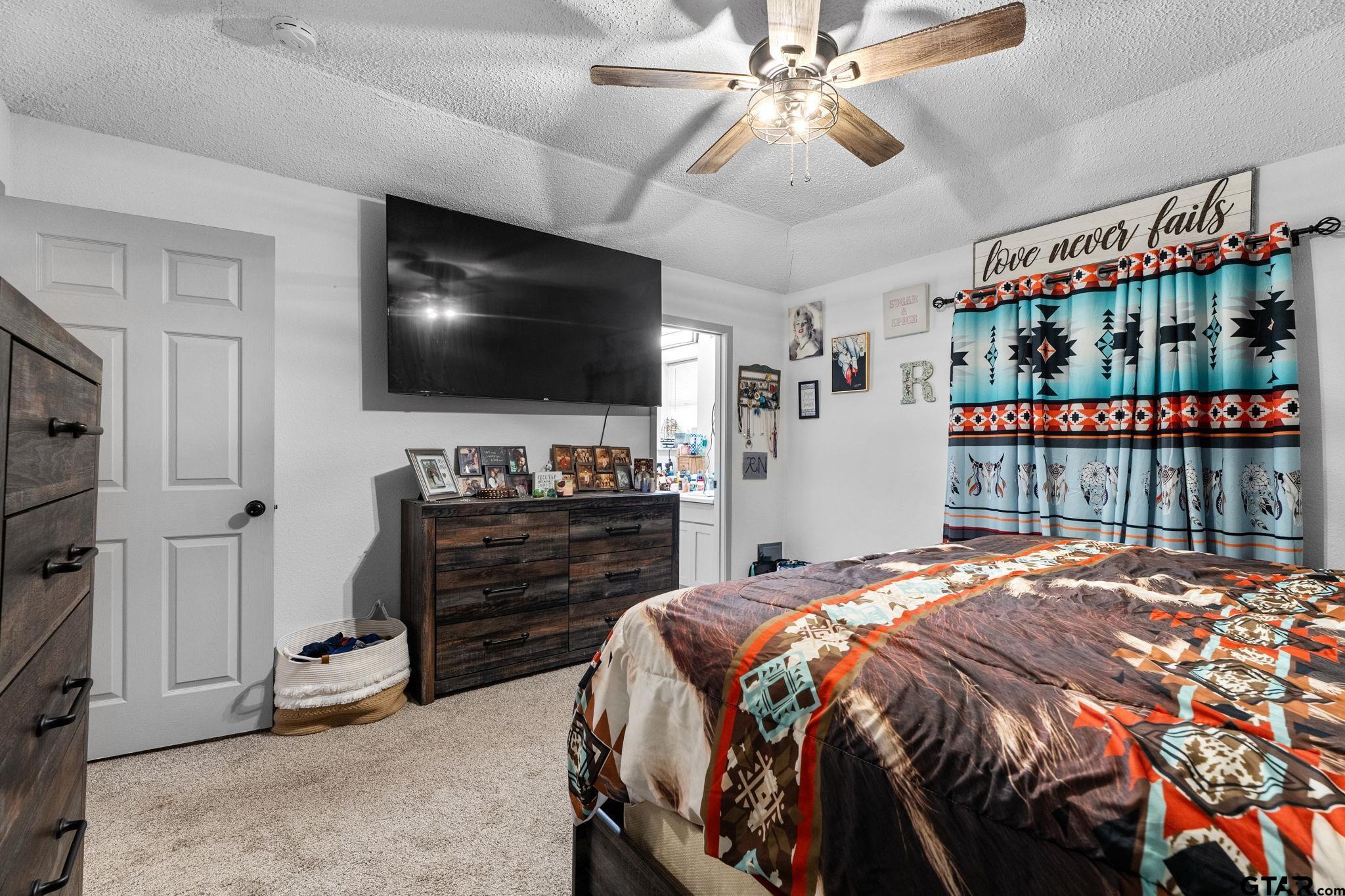 7649 Timber Circle Tyler, TX 75708 - Photo 11 of 25 a bedroom with a bed and a flat screen tv