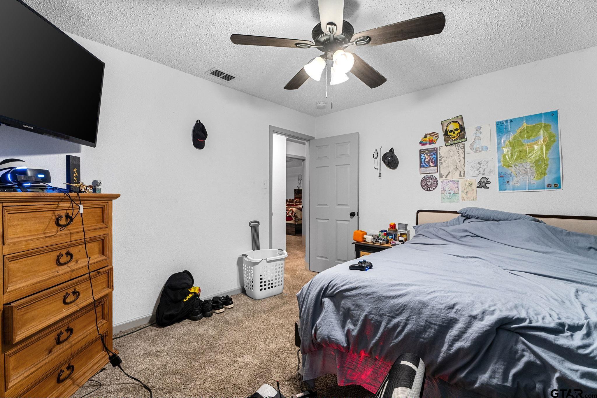 7649 Timber Circle Tyler, TX 75708 - Photo 15 of 25 a bedroom with a bed and a flat screen tv
