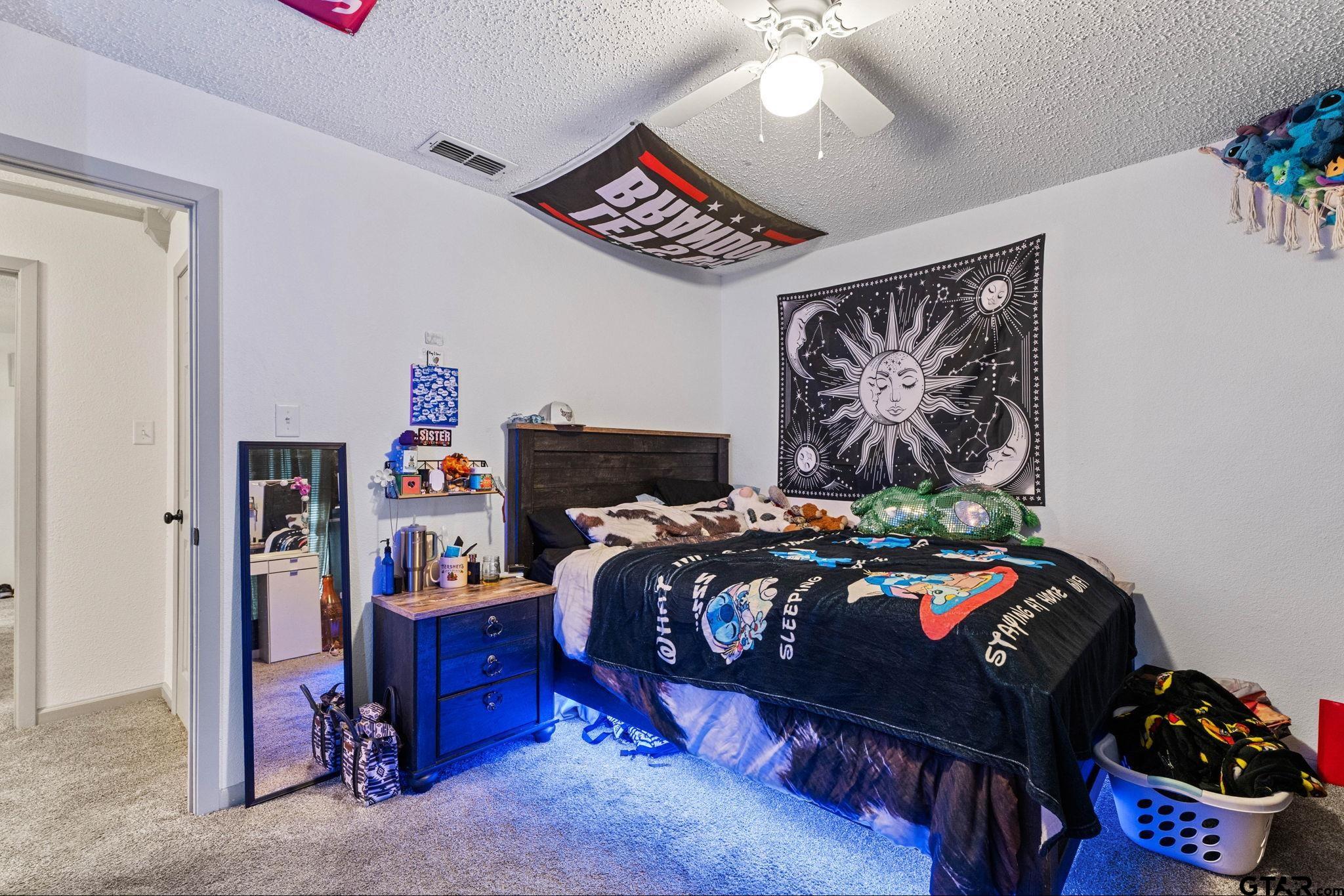 7649 Timber Circle Tyler, TX 75708 - Photo 17 of 25 a bedroom with bed and a bookshelf