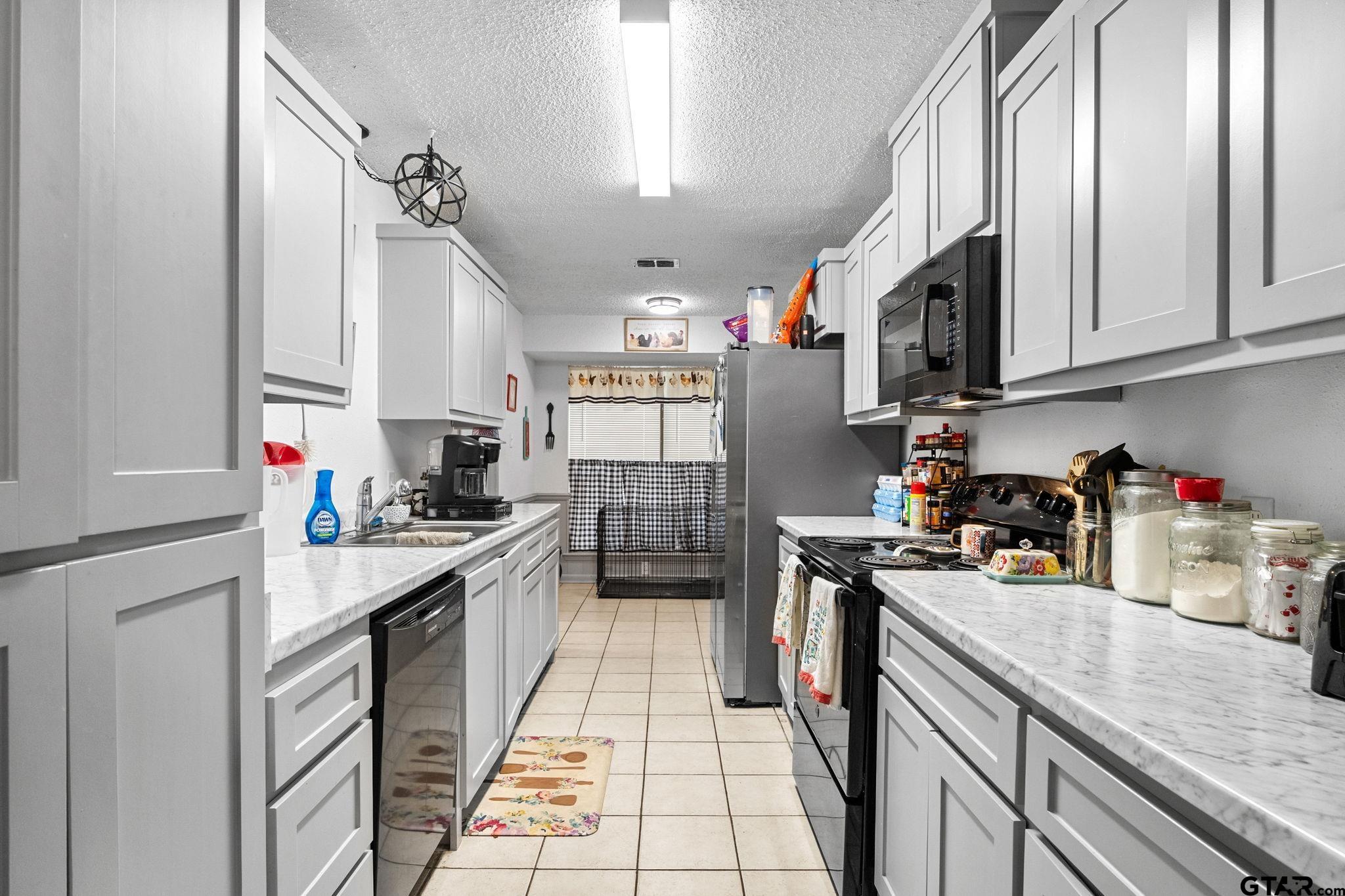 7649 Timber Circle Tyler, TX 75708 - Photo 9 of 25 a kitchen with stainless steel appliances granite countertop a sink stove and refrigerator