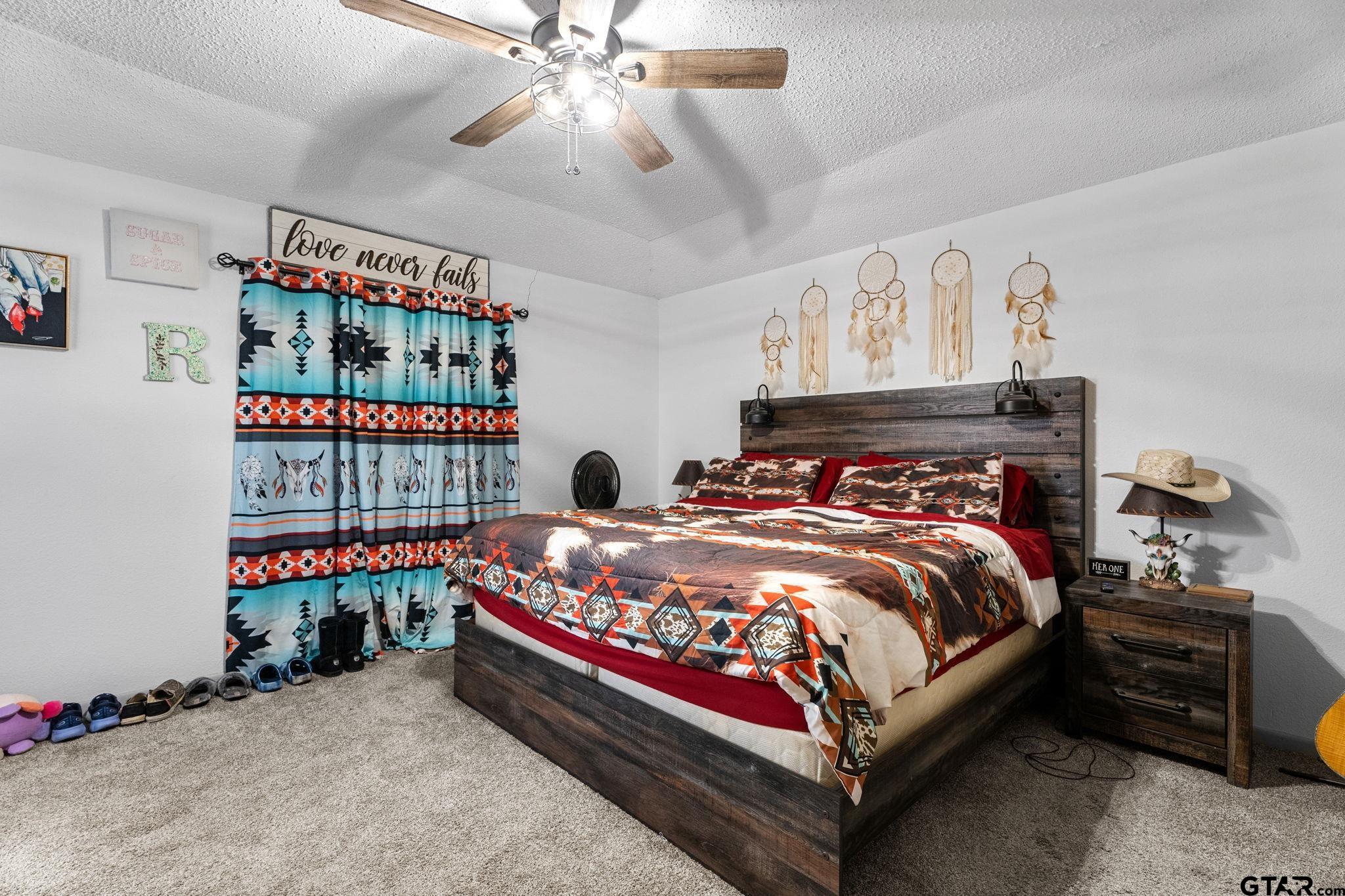 7649 Timber Circle Tyler, TX 75708 - Photo 10 of 25 a bed sitting in a bedroom next to a book shelf