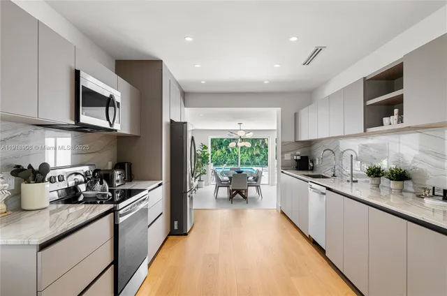 a kitchen with stainless steel appliances a stove a sink a microwave and cabinets