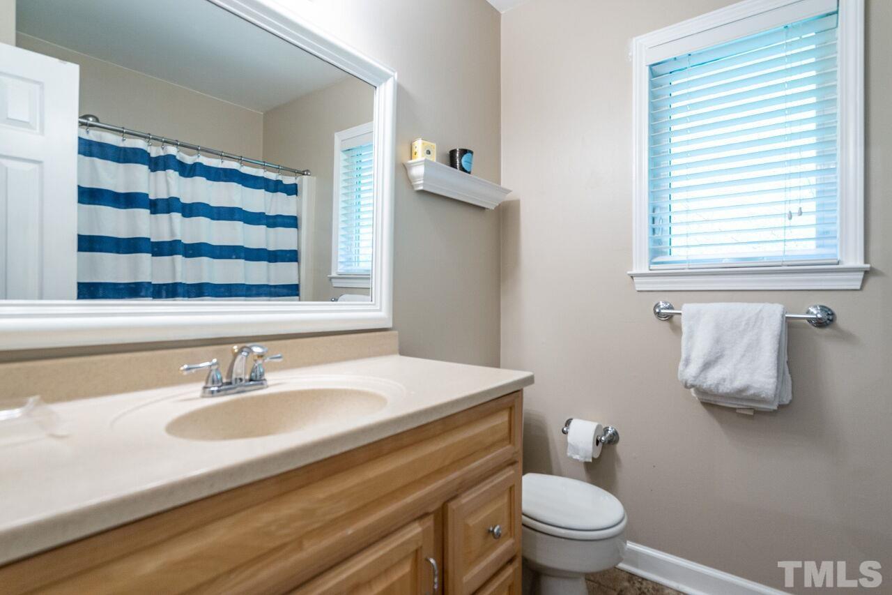 5505 Shadowbrook Drive Raleigh, NC 27612 - Photo 20 of 29 a bathroom with a granite countertop sink toilet and mirror