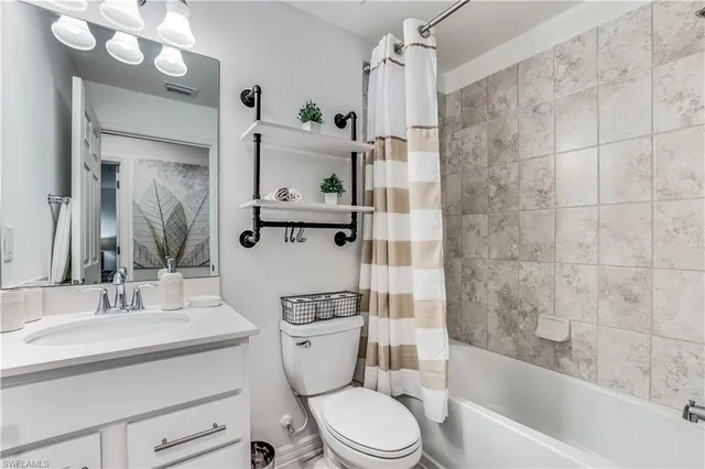 a bathroom with a sink a toilet a mirror a vanity and bathtub