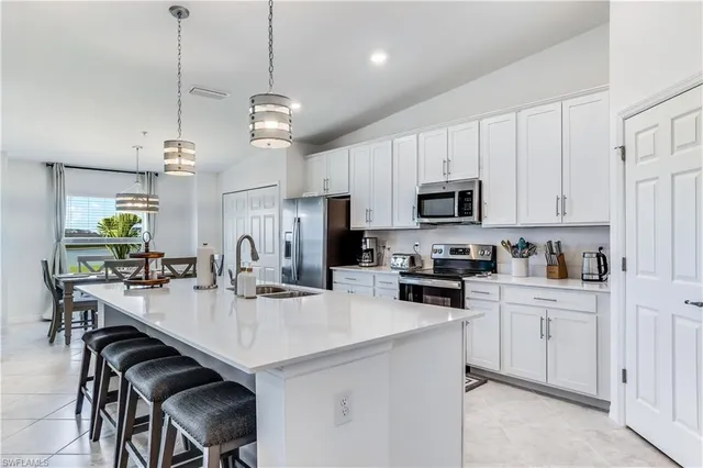 a kitchen with refrigerator cabinets dining table and chairs