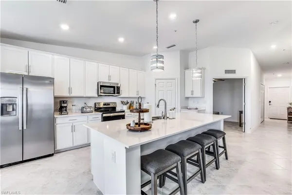 a kitchen with a refrigerator a stove a sink and a center island