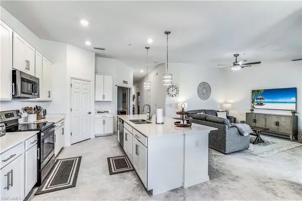 a kitchen with stainless steel appliances granite countertop a stove top oven a sink a stove and a refrigerator