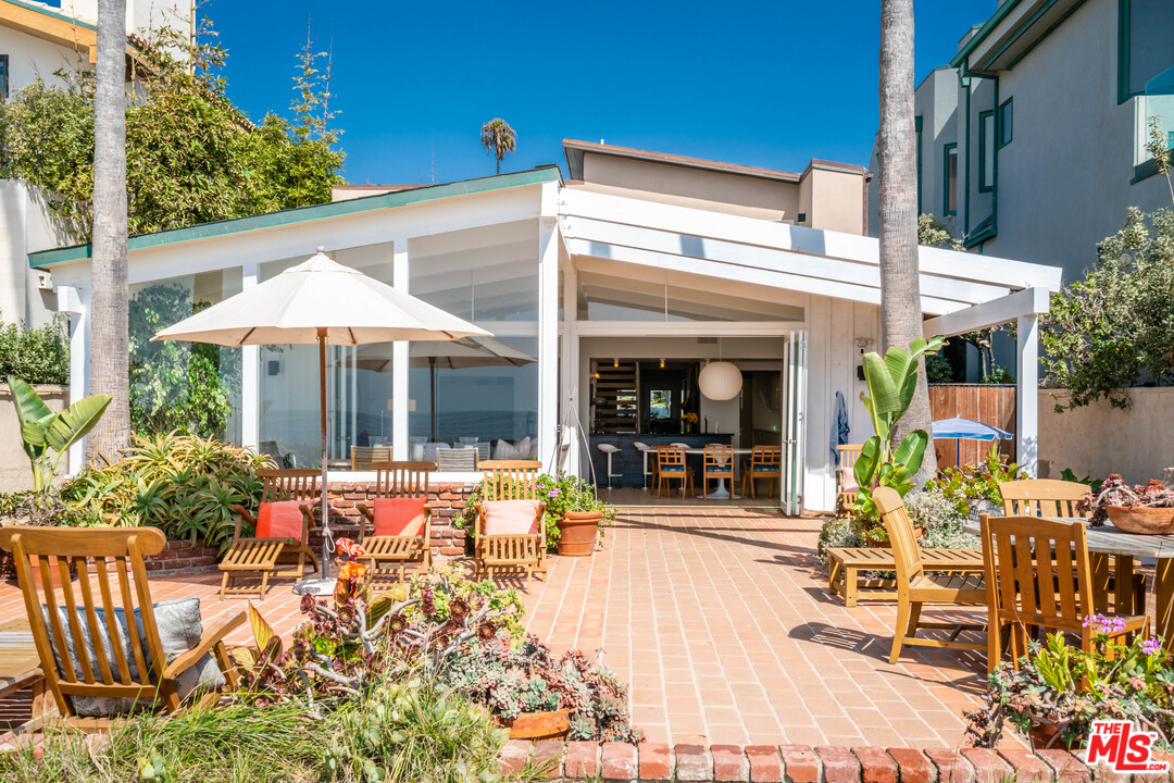 31034 Broad Beach Road Malibu, CA 90265 - Photo 7 of 21 a patio with a table and chairs under an umbrella