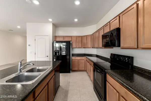 a kitchen with a sink stove top oven and refrigerator