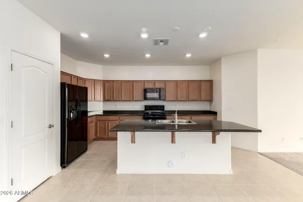 a kitchen with stainless steel appliances granite countertop a sink a stove and a refrigerator
