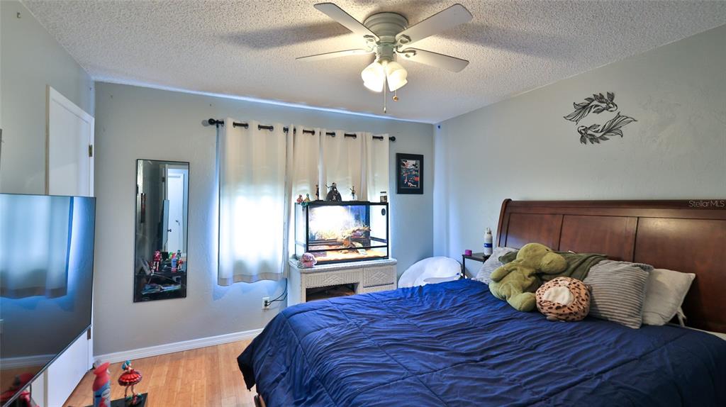 4740 South Atlantic Avenue, Unit 4 Ponce Inlet, FL 32127 - Photo 19 of 38 a bedroom with a bed and a chandelier