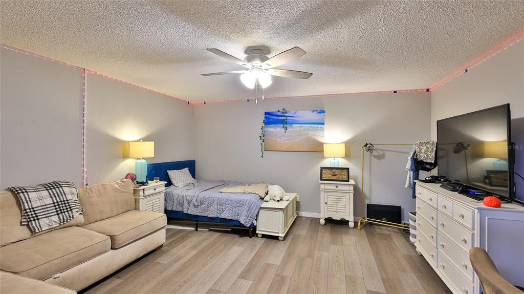 4740 South Atlantic Avenue, Unit 4 Ponce Inlet, FL 32127 - Photo 21 of 38 a bedroom with furniture and a flat screen tv
