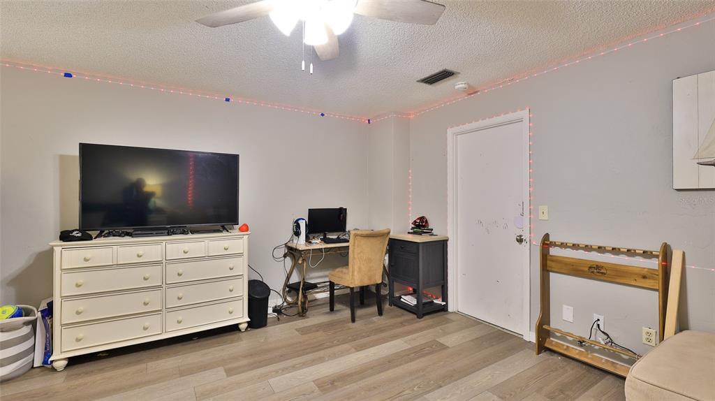 4740 South Atlantic Avenue, Unit 4 Ponce Inlet, FL 32127 - Photo 23 of 38 a livingroom with hardwood area and a flat screen tv