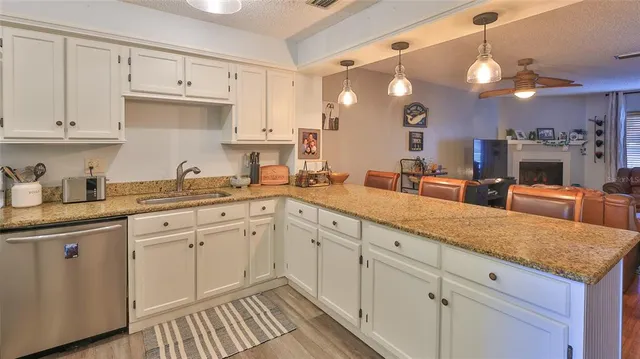 a kitchen with white cabinets and sink