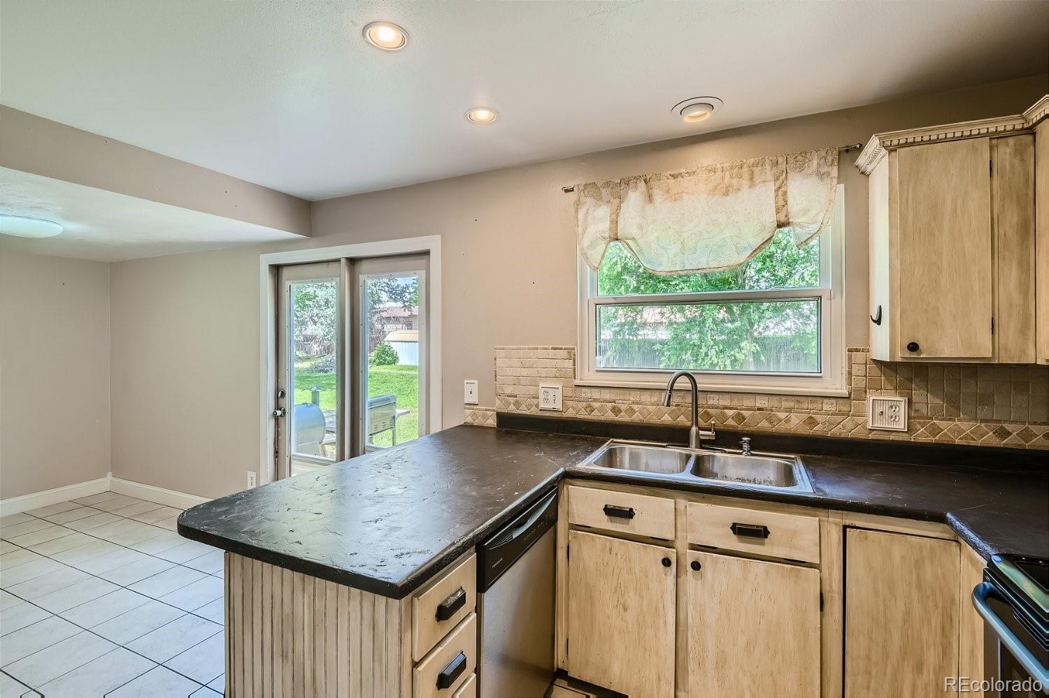 11099 Fairfax Circle Thornton, CO 80233 - Photo 11 of 33 a kitchen with a sink window and cabinets