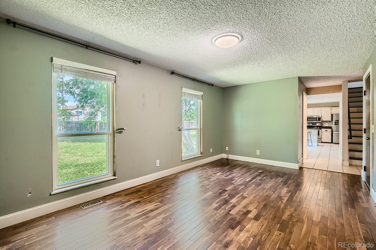 11099 Fairfax Circle Thornton, CO 80233 - Photo 16 of 33 an empty room with wooden floor and windows