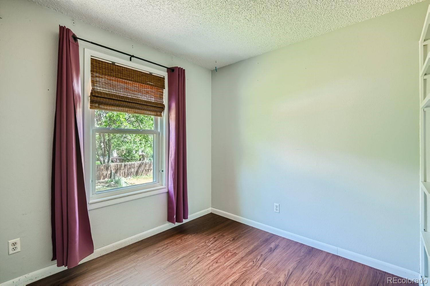 11099 Fairfax Circle Thornton, CO 80233 - Photo 26 of 33 a view of an empty room with wooden floor and a window